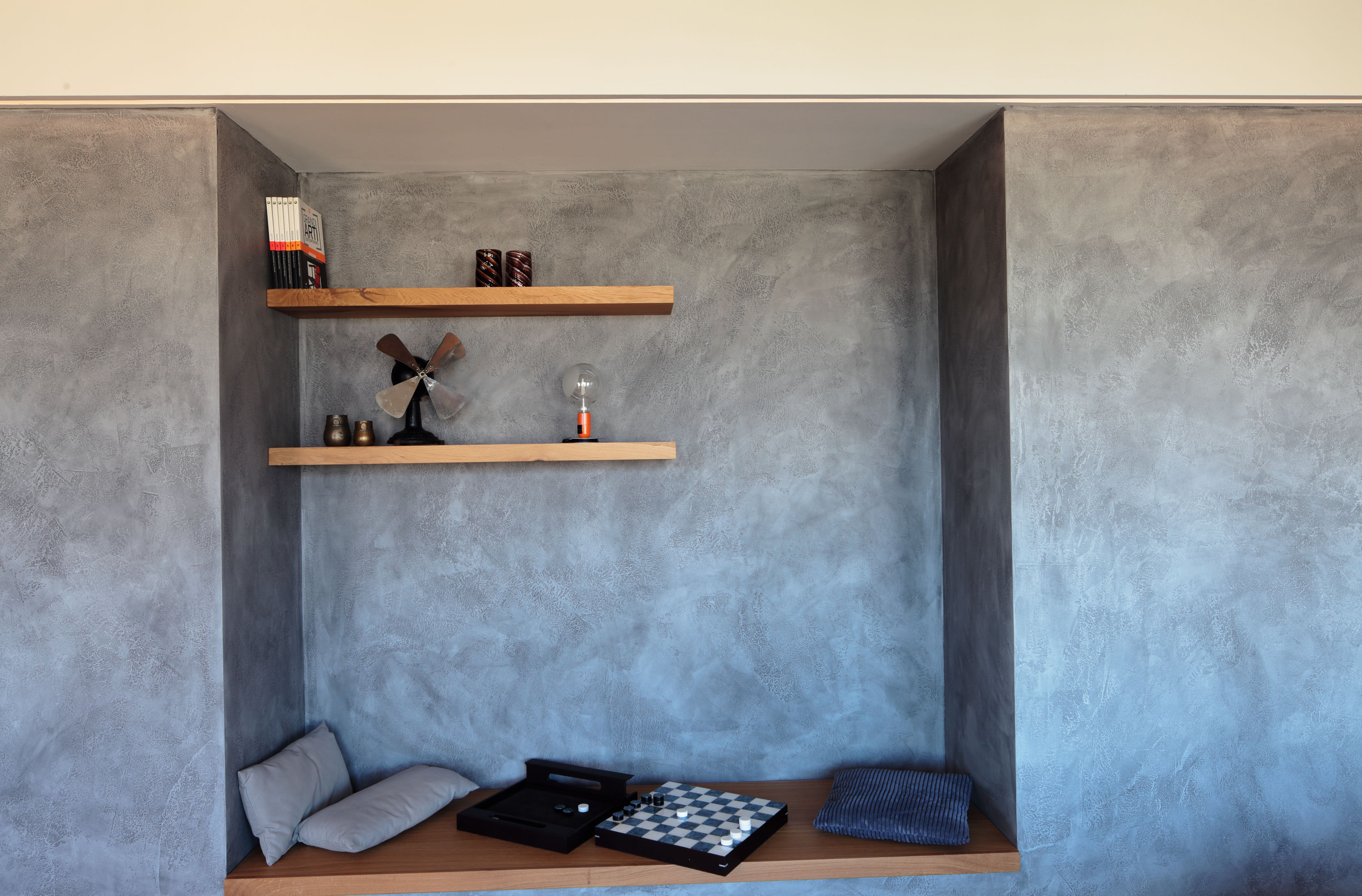 Casa EA, nicchia con panca e mensole integrate nel volume materico